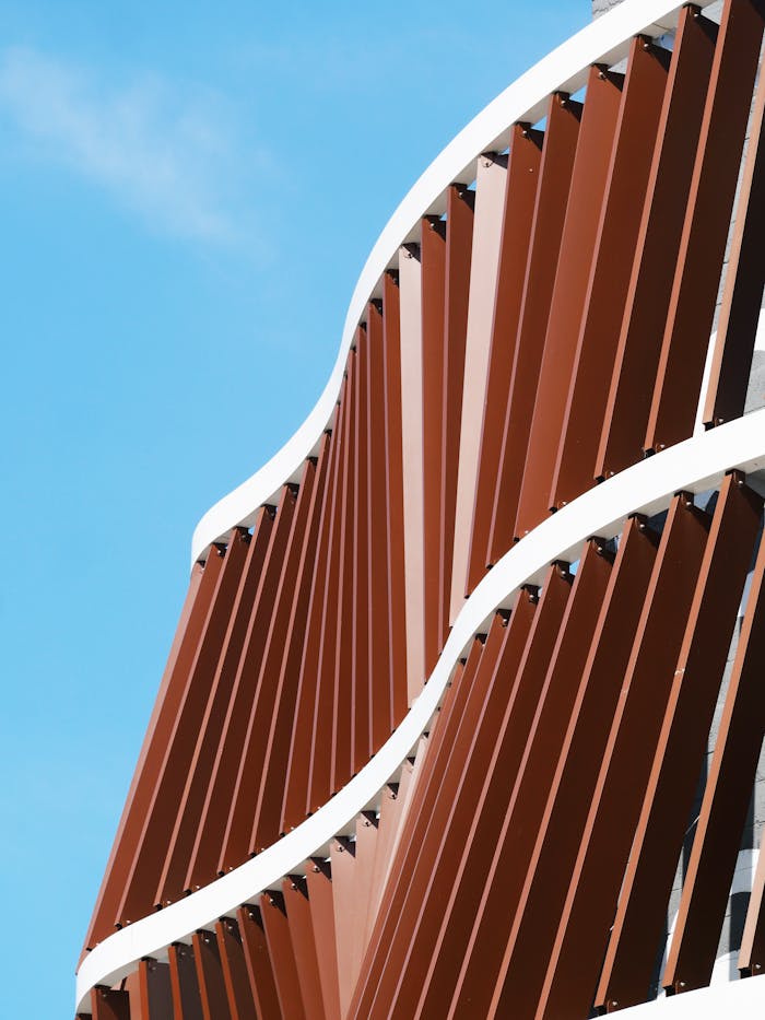 The Art of Drawing Readers In: Your attractive post title goes here Stylish modern building facade with wavy design under a clear blue sky.