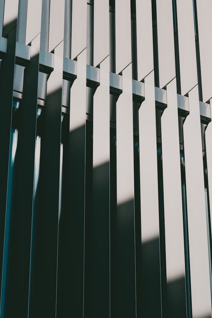 Crafting Captivating Headlines: Your awesome post title goes here Vertical lines on a sunlit modern building facade casting geometric shadows.