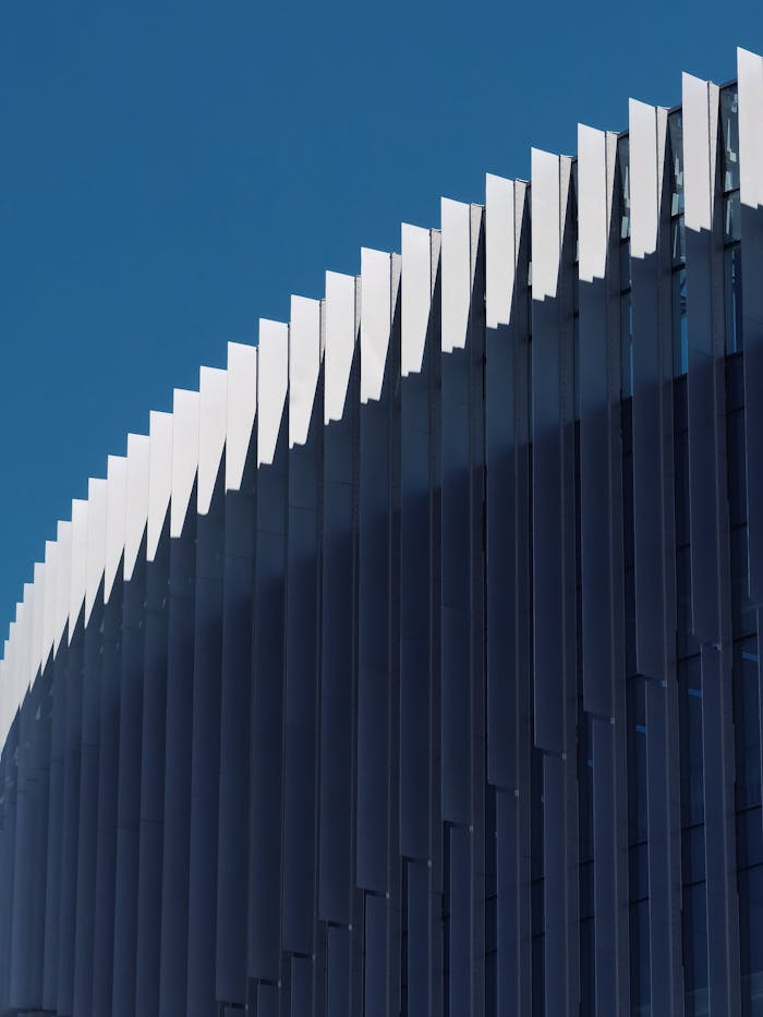 Mastering the First Impression: Your intriguing post title goes here Close-up of a modern building facade with white elements against a clear blue sky.